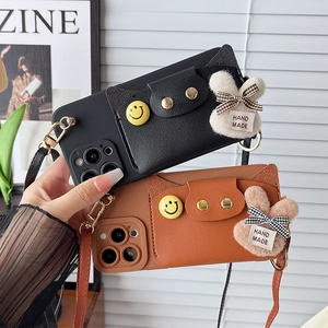 Detail of crossbody phone case with leather card slot and cute plush bunny pendant