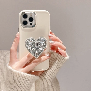 Gros plan d'une coque en silicone crème avec un support luxe en strass en forme de cœur