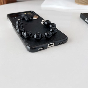 Detail of Galaxy Z Flip case with 3D coffee bear ornament and chunky black bead handle