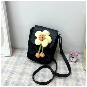 Détail du sac bandoulière noir avec une grande fleur de tournesol jaune et broderies
