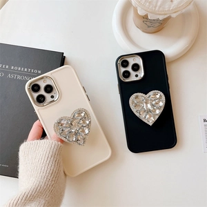 Coque iPhone luxe avec support cœur en strass, disponible en noir et blanc cassé