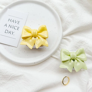 Glossy solid color bow phone grips in yellow and green with elegant pleated texture