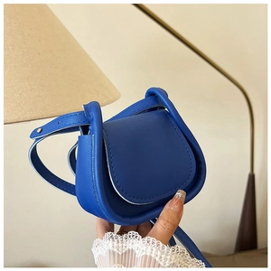 Dettaglio ravvicinato di una mini borsa in pelle blu brillante con trama litchi e tracolla