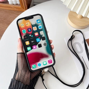 Black iPhone case with adjustable crossbody strap and metal hooks on a white desk