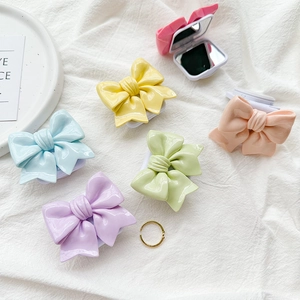 Detail view of macaron-colored bow-shaped mirror boxes in six vibrant pastel shades