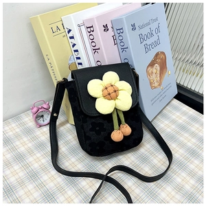 Gros plan sur le mini sac bandoulière noir avec une grande fleur de soleil 3D