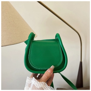 Dettaglio mini borsa a tracolla verde in ecopelle con cuciture spesse a bordo tondo