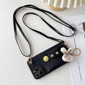 Detail of iPhone case with crossbody strap, black leather card holder and plush rabbit charm