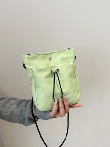 Minimalist light green canvas phone bag with drawstring front pocket and crossbody strap