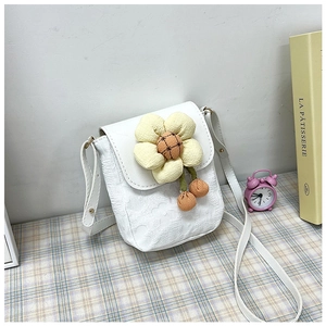 Détail du sac bandoulière en dentelle blanche avec fleur en peluche jaune