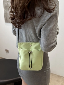 Minimalist avocado green canvas phone bag with drawstring front pocket and black rope strap