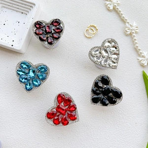 Macro shot of colorful rhinestone heart phone grips with luxury sparkling gems on white texture