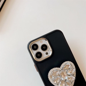 Détail de la coque en silicone noir avec support cœur en strass et bordure dorée