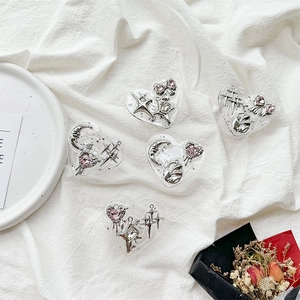 Macro detail of heart-shaped resin phone grips with silver moon and bow charms