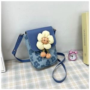 Détail du sac à bandoulière floral avec tissu bleu et breloque fleur jaune en 3D