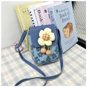 Détail d'un sac à bandoulière bleu à fleurs avec une grande fleur 3D jaune et breloques