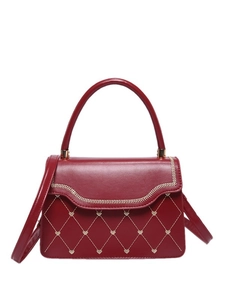 Red heart-quilted leather handbag with golden wave stitching and detachable crossbody strap