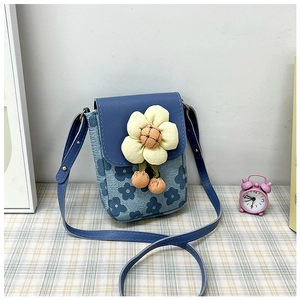 Détail de la pochette téléphone à fleurs avec fleur tricotée jaune et texture denim bleu