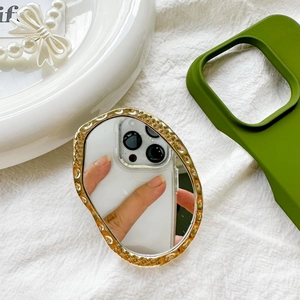 Close-up of golden irregular metal mirror phone grip with hammered texture detail