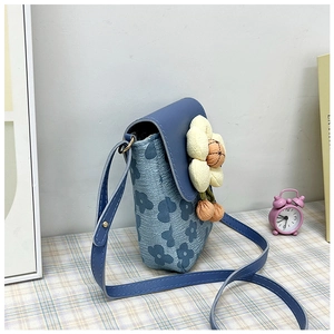 Gros plan sur le sac floral bleu avec fleur 3D sur une nappe à carreaux vichy