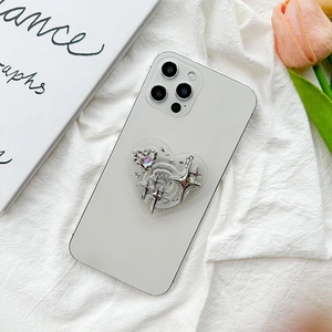 Detail of a heart-shaped phone socket with silver stars and pink crystal on white phone