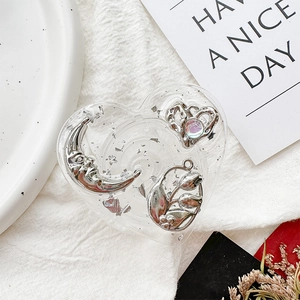 Detail of heart resin phone grip with silver foil and metal charms like moon and tulip