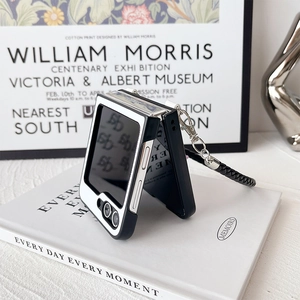Detail of a luxury black and white folding phone case with a woven hand strap for Samsung