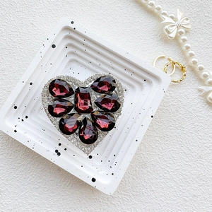 Macro detail of luxury heart-shaped rhinestone phone grip with deep purple faceted gems