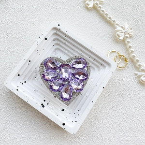 Macro view of luxurious purple rhinestone heart phone grip with sparkling crystals