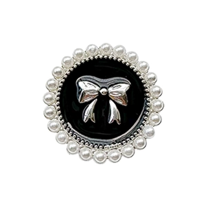 Black round phone grip with silver bow and pearl trim on a white background