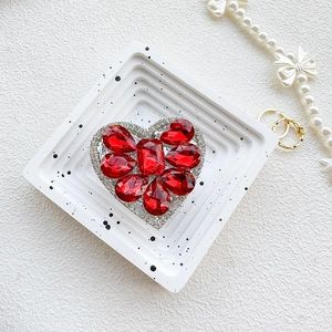Detailed view of luxury heart-shaped grip with red crystals and silver rhinestone border