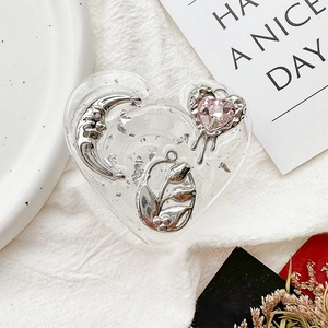 Detail view of heart-shaped resin phone grip with silver moon and tulip foil accents
