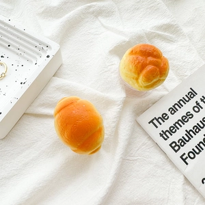 Detailed view of realistic 3D croissant phone grip on a white linen aesthetic setting