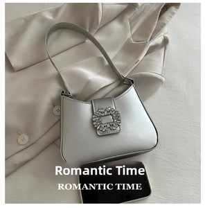 Close-up of silver leather underarm bag featuring a large square rhinestone buckle