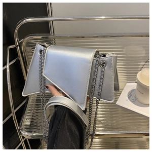 Gros plan sur le sac géométrique argenté avec bandoulière chaîne et finition moderne
