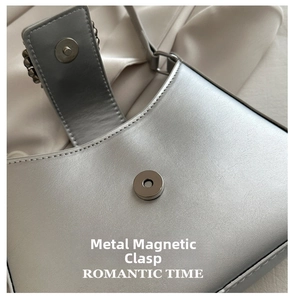 Detailed view of the magnetic metal clasp on a premium silver leather shoulder bag