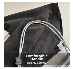 Detailed macro view of the silver leather bag featuring double-knotted handle craftsmanship