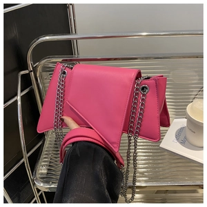Détail du sac à bandoulière rose fuchsia avec chaîne argentée et rabat géométrique