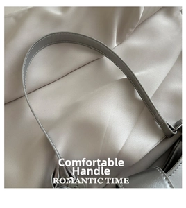 Close-up of grey leather handbag handle with white contrast stitching and soft texture