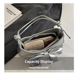 Detailed internal view showing capacity of silver bow shoulder bag with essentials