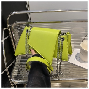 Détail du sac à bandoulière géométrique vert citron avec chaîne argentée et poignée