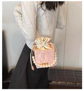 Detailed view of pink marble pattern bucket bag with pearl handle and chain strap