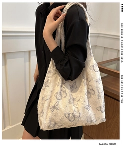Detail shot of the jacquard fabric butterfly pattern and raw fringe edges on the tote bag