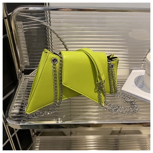 Détail du sac à bandoulière géométrique vert néon avec chaîne argentée sur support