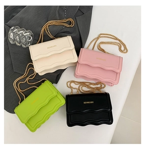 Detail view of wavy flap small square bags in four colors with golden chain straps
