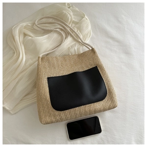 Detailed top view of beige woven tote bag with nautical rope strap and phone for scale