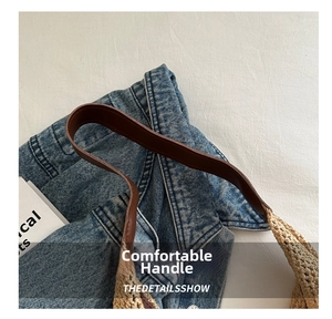 Detailed view of brown leather handle stitching on a woven straw tote beach bag