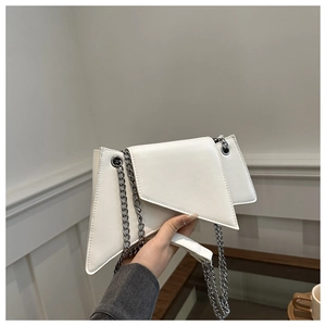 Gros plan du sac à bandoulière géométrique blanc avec sa chaîne métallique élégante