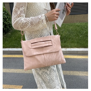 Detail of light pink PU leather crossbody bag with unique marble wave texture and strap