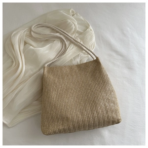 Detailed view of beige woven tote bag with herringbone pattern and cotton rope strap